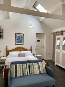 a bedroom with a bed and a blue couch at Jollys of Goodrich in Goodrich