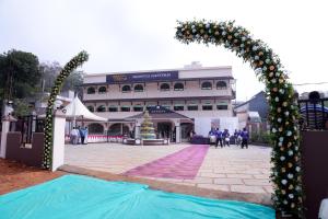 an arch in front of a building with people in front at ROYAL CASTLE HOTEL in Mananthavady