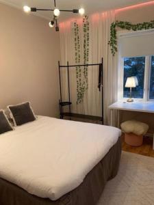 a bedroom with a large bed with a window at Stort hus i Stockholm in Sollentuna