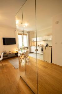 a kitchen and living room with a table and a refrigerator at Przytulne mieszkanie na ulicy Chmielna w samym centrum Warszawy in Warsaw