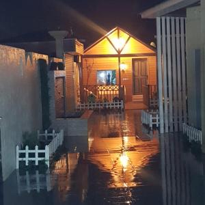 a house in the rain on a flooded street at كوخ ريفي تنومه in Tanomah