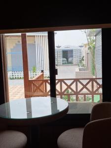 Cette chambre dispose d'une table en verre et offre une vue sur le patio. dans l'établissement كوخ ريفي تنومه, à Tanomah