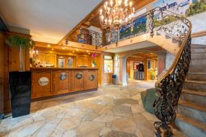 a staircase in a home with a chandelier at Alpin & Wellness Resort Ludwig Royal in Oberstaufen