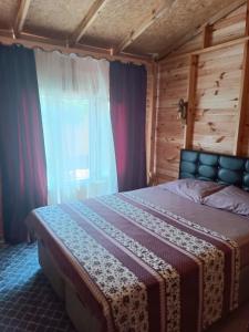 a bedroom with a bed and a window with curtains at Es&Es campıng ve bungalov in Köyceğiz