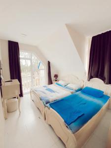 a bedroom with two beds and a large window at Cottage Tbiliselebi in Ureki
