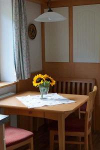 聖安東阿爾貝格的住宿－Apartpension Schollberg，一张桌子上放着向日葵花瓶