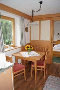 una cocina con mesa y sillas con un jarrón de flores en Apartpension Schollberg en Sankt Anton am Arlberg