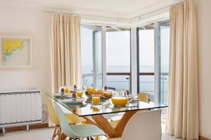 a dining room with a table with fruit on it at Marine Point, Mevagissey - sensational cliff top views of harbour and bay in Mevagissey