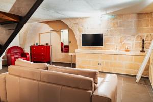 a living room with a couch and a tv at Ai Quarti Sottani in Matera