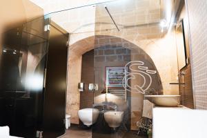 a bathroom with two toilets and a sink at Ai Quarti Sottani in Matera