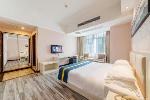 Habitación de hotel con cama y TV en Unitour Hotel, Nanning Dongge Traditional Chinese Medicine No 1 Affiliated, en Nanning