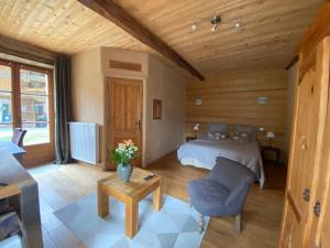 Saint-LattierにあるGites&chambres d hôtes Les granges du Fournelのベッドルーム1室(ベッド1台、椅子、テーブル付)