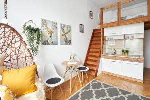 Apartments on Miodowa في كراكوف: مطبخ صغير مع طاولة وكراسي في الغرفة