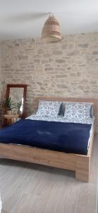 een slaapkamer met een bed met een blauw dekbed bij Sous le Tilleul in Saint-Maurice-de-Cazevieille