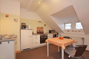 a kitchen with a table and a stove and a sink at Haus Cäcilie in Oberhof