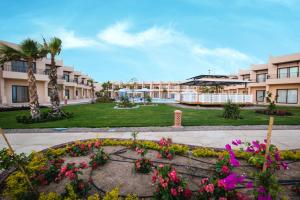 een binnenplaats van een gebouw met bloemen en palmbomen bij Sky View Suites Hotel in Hurghada