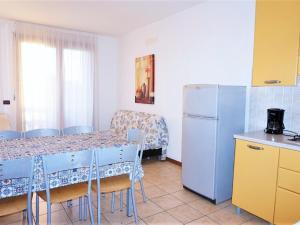 een keuken met een tafel met stoelen en een koelkast bij Pleasant villa in Carole with shared pool in La Fagiana