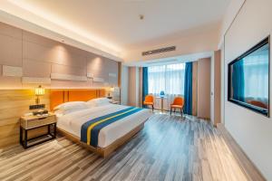 Habitación de hotel con cama y TV en Unitour Hotel, Nanning Dongge Traditional Chinese Medicine No 1 Affiliated, en Nanning