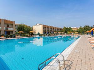 een groot zwembad met stoelen en parasols bij Pleasant villa in Carole with shared pool in La Fagiana
