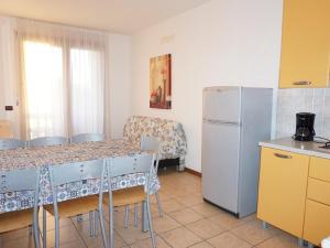 een keuken met een tafel met stoelen en een koelkast bij Pleasant villa in Carole with shared pool in La Fagiana