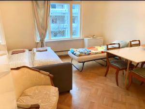 Zimmer mit Sofa, Tisch und Fenster in der Unterkunft Villa Internationals in Oslo