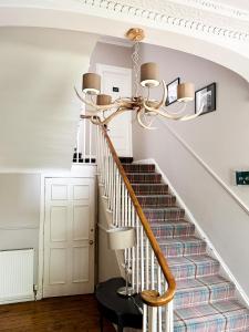 a staircase in a home with a chandelier at The Glen Mhor Apartments in Inverness