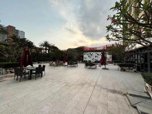 un patio con mesas, sillas y sombrillas en Santavan Hotel Shenzhen Guangming, en Bao'an