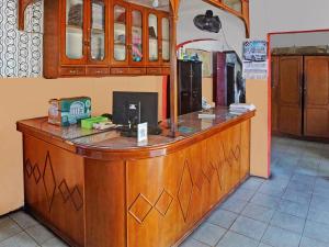 a large wooden counter in a kitchen with a counter top at OYO 92579 Hotel Mutiara in Pematangsiantar