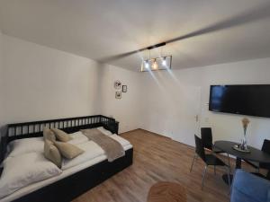 Schlafzimmer mit einem Bett, einem Tisch und einem TV in der Unterkunft Exklusive Gartenwohnung in Wien