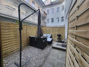 eine Terrasse mit einem Zaun und einem Sonnenschirm in der Unterkunft Exklusive Gartenwohnung in Wien