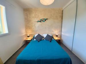 a blue bed in a small room with two tables at Appartements Candella in Galeria