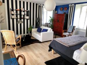 a bedroom with a bed and a couch and a chair at Chambres De St Michel in Paimpol