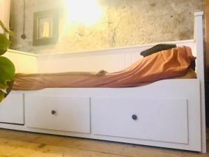 a white bed with a blanket on top of it at Bookstor Atelier in The Hague