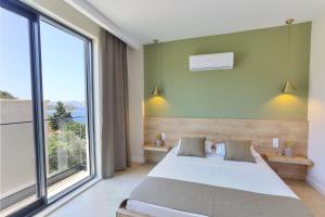 ein Schlafzimmer mit einem Bett und einem großen Fenster in der Unterkunft Kaktus Suites in Kaş