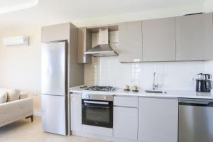 a white kitchen with a stove and a refrigerator at Kaktus Suites in Kas