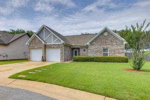a large brick house with a grass yard at Pet-Friendly Home with Fenced Backyard in Moundville in Moundville