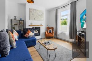 a living room with a blue couch and a table at Luxe Garden House for 6 in Central Exeter in Exeter