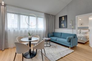 a living room with a blue couch and a table at Waterlane Vintage - Fitness & Gym by Downtown Apartments in Gdańsk