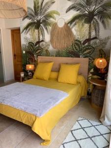 a bedroom with a bed with yellow pillows and palm trees at Chambre d'hôtes Chante Cigale in La Ciotat