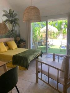 a bedroom with a bed and a table and a patio at Chambre d'hôtes Chante Cigale in La Ciotat