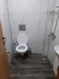 a white bathroom with a toilet and a sink at Hotel kafkasya in Kars