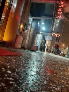 a wet street in front of a building at night at Hotel kafkasya in Kars