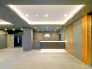 an office lobby with a reception desk in the middle at Hotel Livemax Premium Nagano Ekimae in Nagano