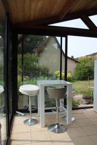 une table blanche et deux tabourets sur une terrasse dans l'établissement Le TIVOLI, à Montignac