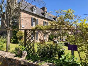 an old stone house with a sign in front of it at Chambres De St Michel in Paimpol
