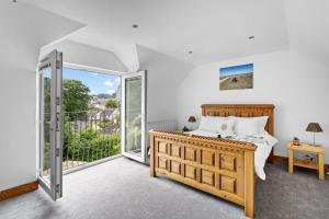 a bedroom with a bed and a balcony at Trade Winds, Brixham in Brixham