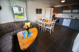 a living room with a couch and a table at Sjølund house in Dragøya