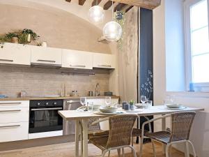 Una cocina con una mesa y sillas en una cocina. en Suite 9, Parma Centro, en Parma