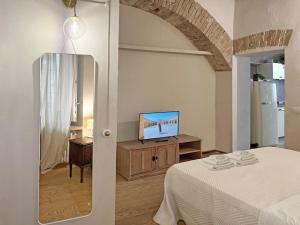 1 dormitorio con 1 cama y TV en una mesa en Suite 9, Parma Centro en Parma