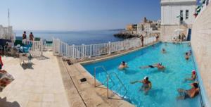 - un groupe de personnes dans une piscine près de l'océan dans l'établissement Residence Porto Miggiano, à Santa Cesarea Terme